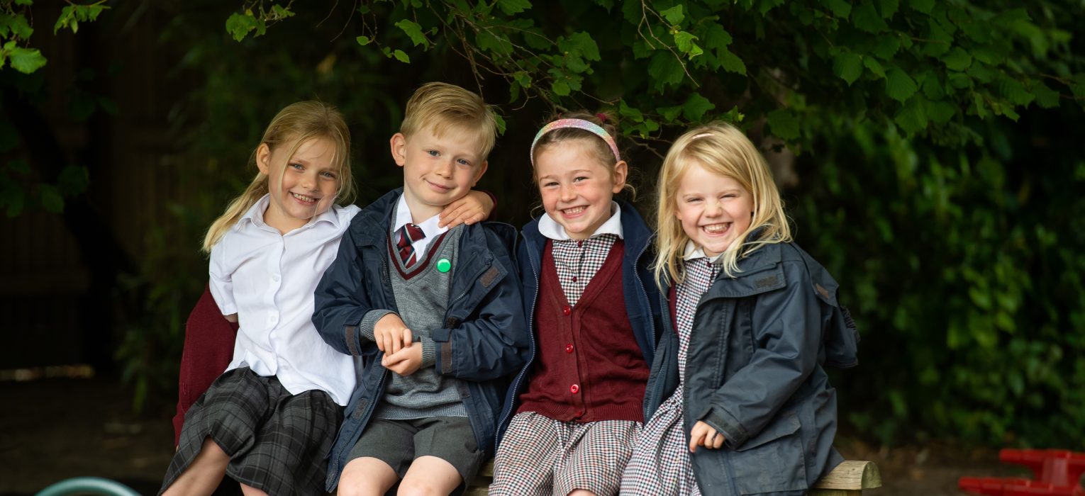 4 young students sat on a bench
