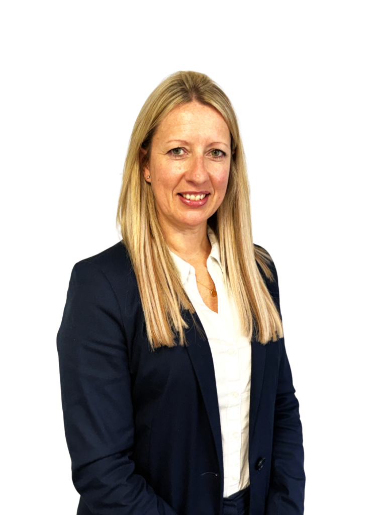 Head-and-shoulders portrait of a smiling woman with long blonde hair, wearing a navy blazer and white blouse against a black background