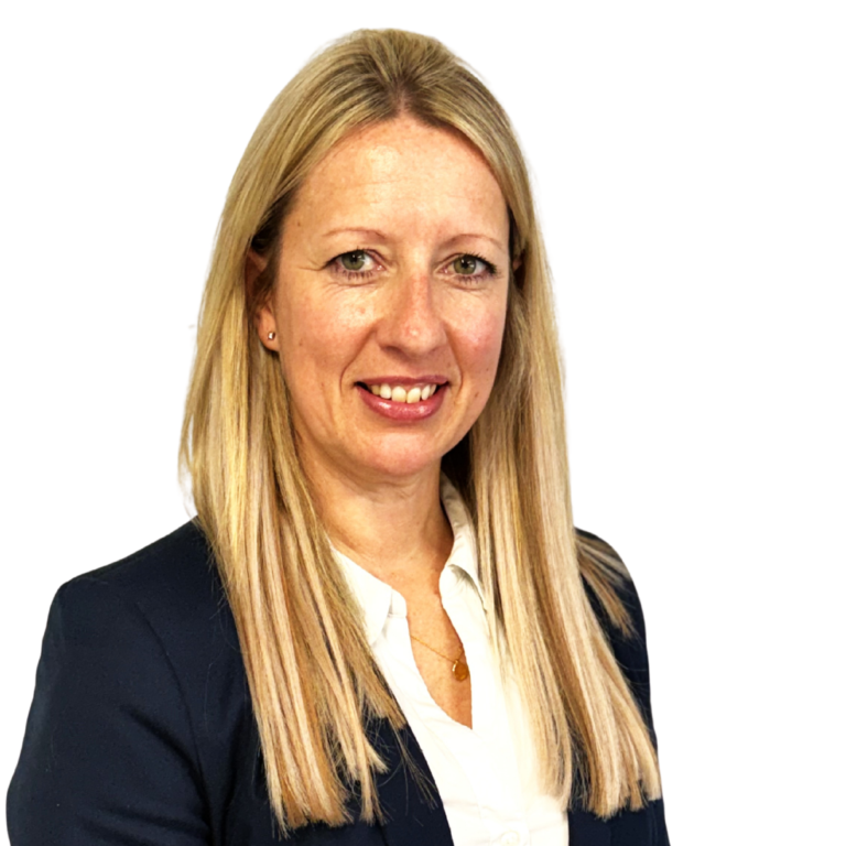 Head-and-shoulders portrait of a smiling woman with long blonde hair, wearing a navy blazer and white blouse against a black background